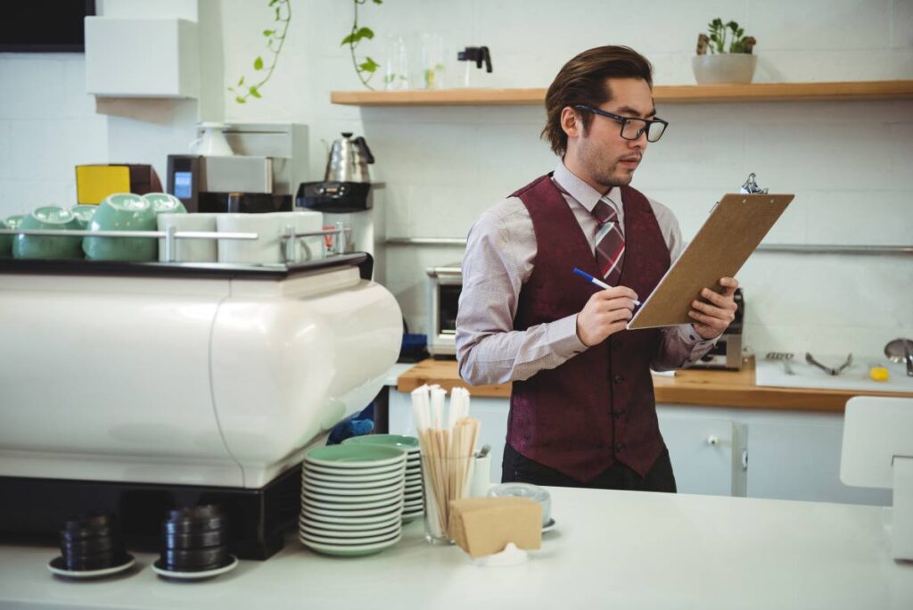 man writing with pen clipboard